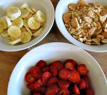 A bowl of fruit on a plate, with Strawberry and Banana